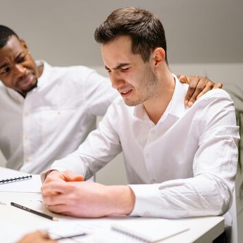 Krisengespräche kompetent führen Seelische Erste Hilfe leisten Workshop Mann gibt anderem Mann psychische Unterstützung indem er seine Hand auf dessen Schulter legt