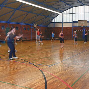 Zumbaworkout in Turnhalle eine Gruppe Menschen beim Zumba in einer Turnhalle