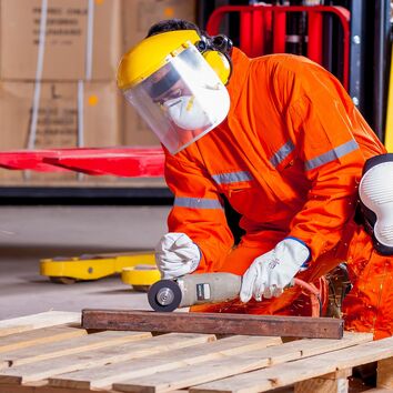Ergonomische Haltung beim Flexen Mann beim Flexen von Metall hockend