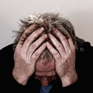 Stressbewältigung & Entspannung Mann stützt sich gestresst auf seine Hände